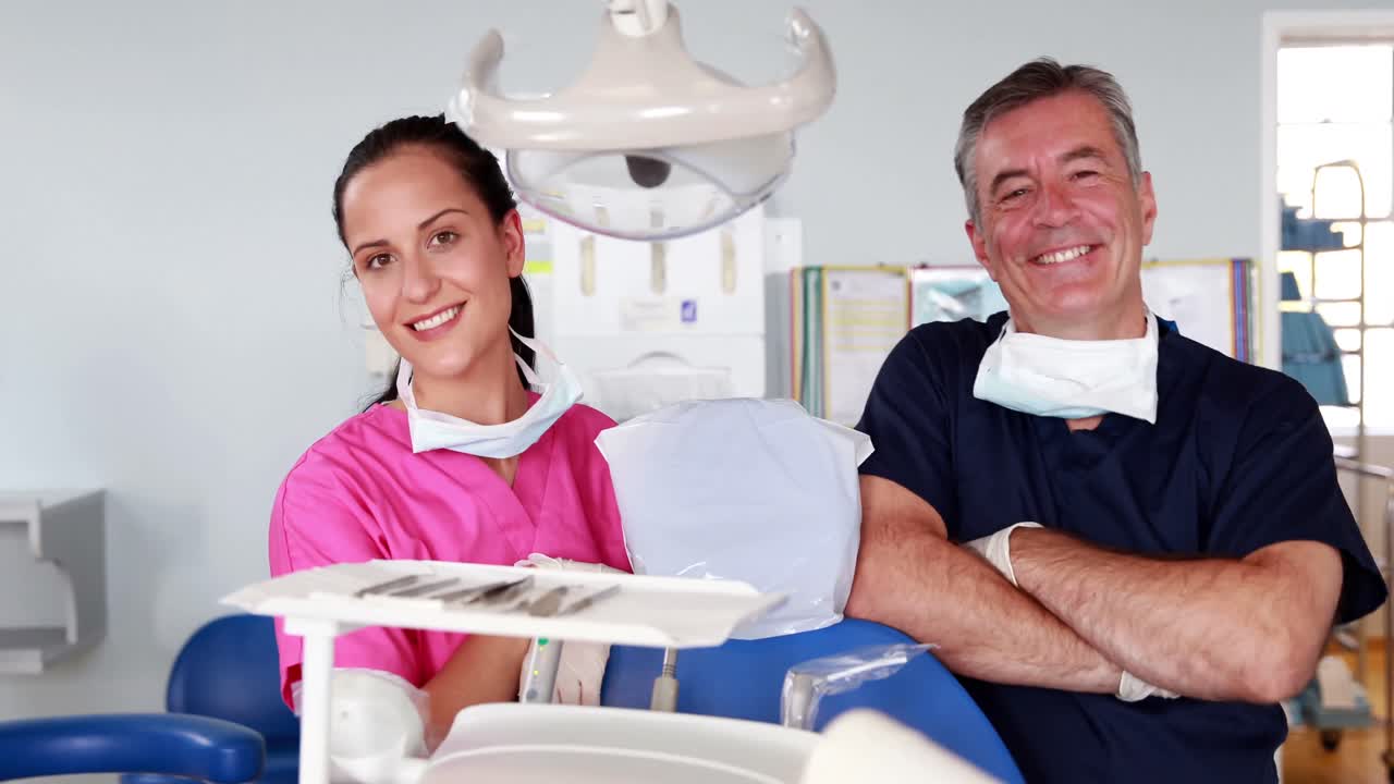 Smiling medical team taking off a surgical mask