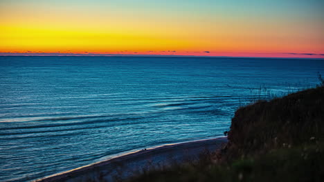 Zeitrafferaufnahme-Des-Orangefarbenen-Sonnenuntergangs-Am-Himmel-Und-Des-Sich-Bewegenden-Blauen-Ozeanwassers-Am-Abend