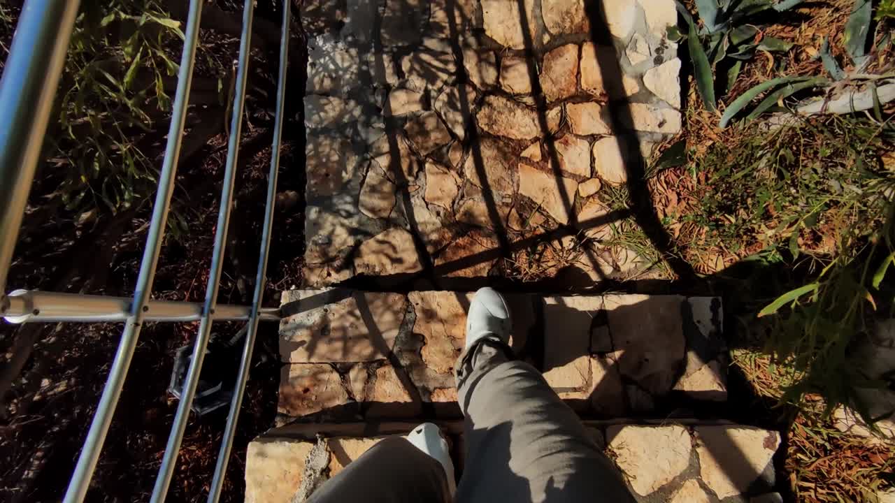 밖의 오래된 돌 계단에서 내려가는 남자의 개인적인 관점에서 촬영 된 낮은 섹션