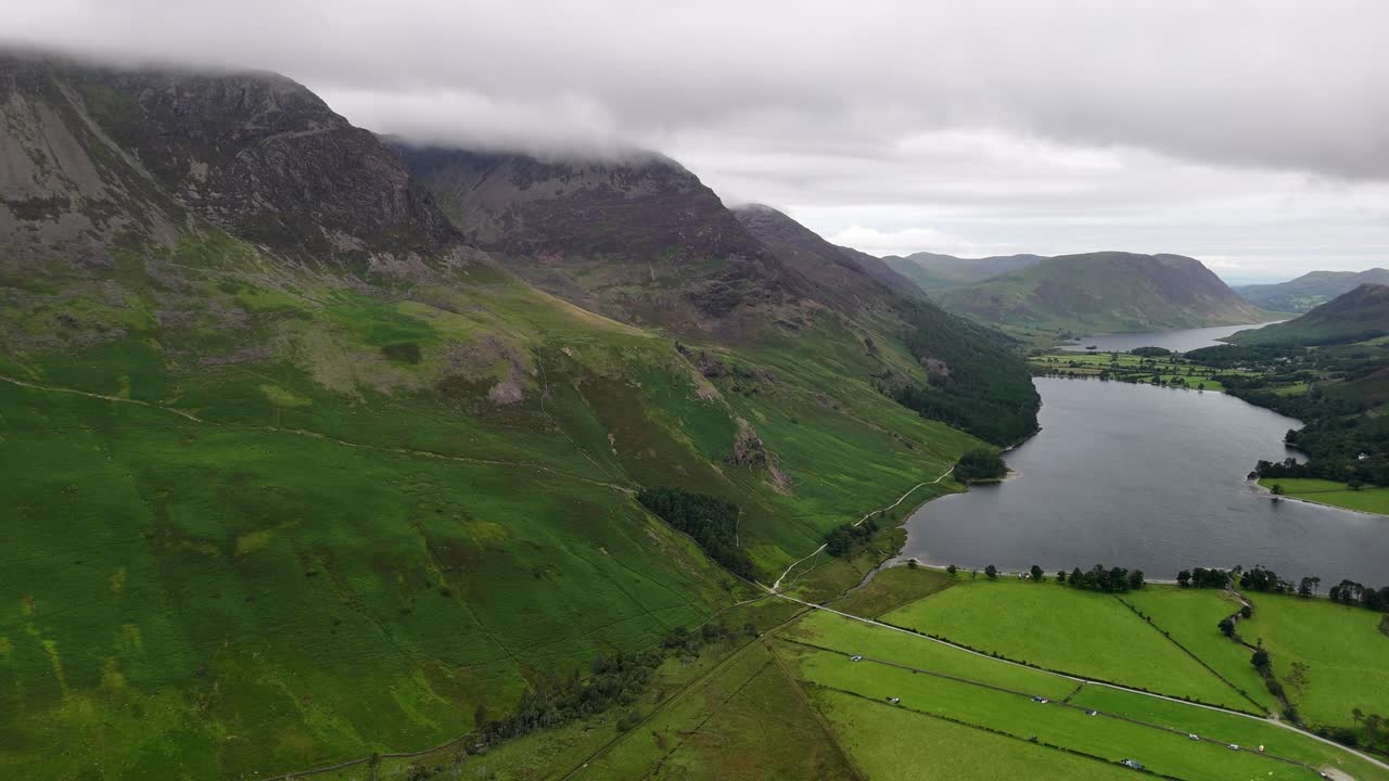 panoramic Aerial drone shot of Buttermere and crummock lake in the Lake District on a moody, overcast day with mountains and forest