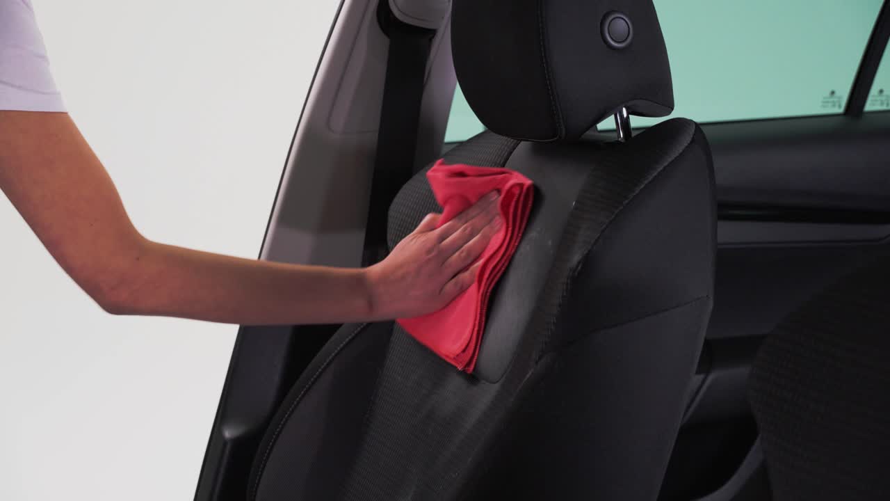 un hombre limpiando el asiento con un paño de microfibra
