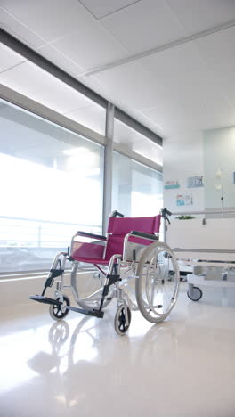 vertical video of empty wheelchair and patient bed in the hospital ward