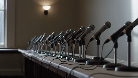 row of microphones on a conference table