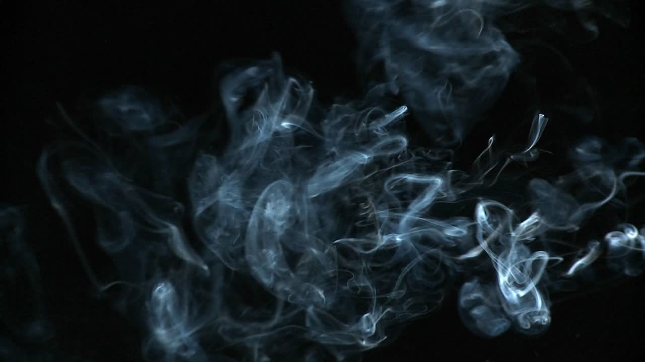 검은 배경에 담배 연기가 뿜어져 나오고 있다