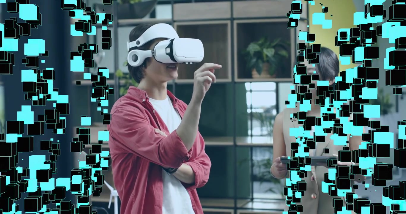 Uomo che attiva un visore VR per una demo tecnologica e guida grafici a cubo mentre un collega usa un tablet per i dati.