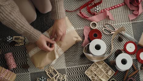 top view of caucasian woman wrapping christmas gifts on the floor.