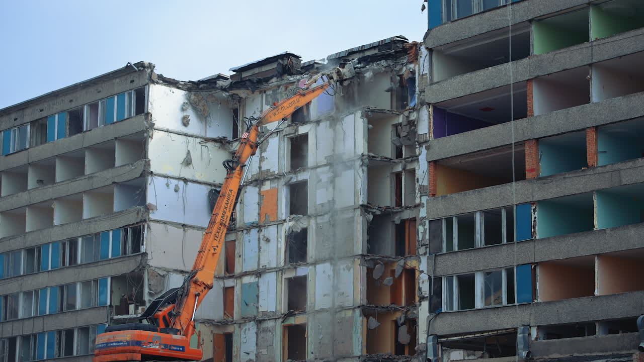 Demolition Of Old Residential Building. Destroying Old Concrete Building Using Mechanical Arm of Bulldozer on Construction Site.