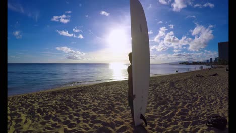 surfista con una tabla de surf de pie en la playa 4k