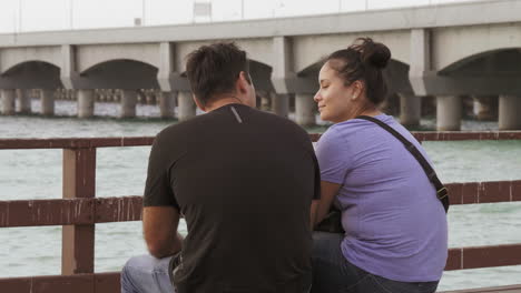 pareja sentada en un banco en el muelle