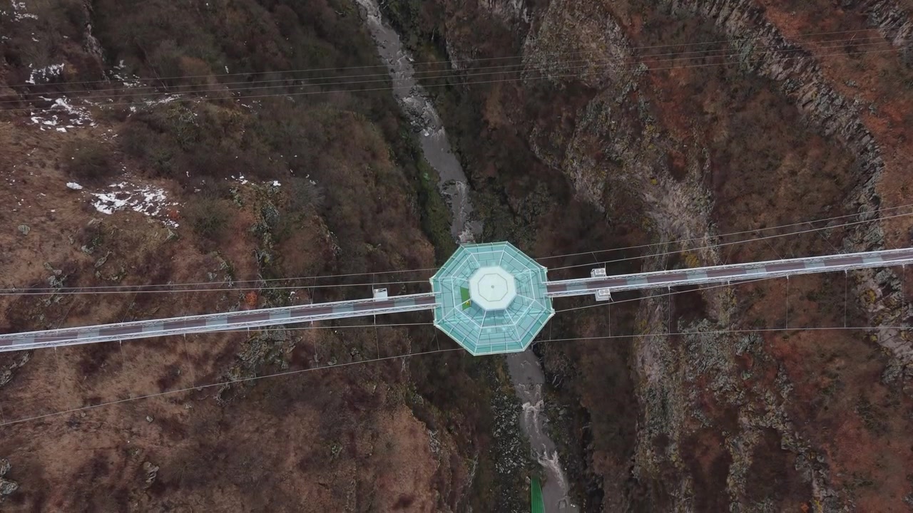 Ripresa panoramica con drone che si avvicina al Ponte di Diamante nel Canyon di Dashbashi, rivelando il paesaggio drammatico e l'impressionante profondità del canyon.