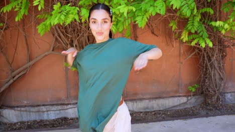 woman dancing in front of vine wall