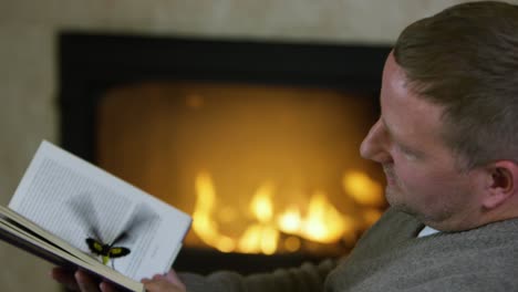 man reading by the fireplace