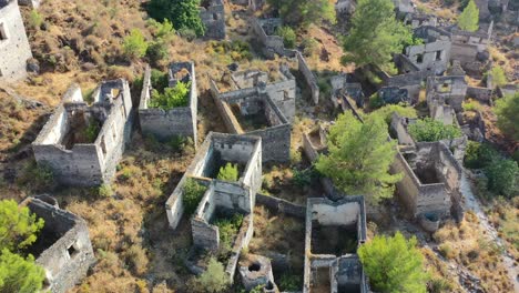 Antena-Macro-De-Los-Edificios-Abandonados-En-Ruinas-En-La-Famosa-Ciudad-Fantasma-Del-Pueblo-De-Kayakoy-En-Fethiye,-Turquía,-En-Un-Día-Soleado-De-Verano