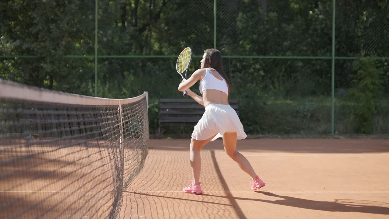 여자 테니스 선수 가 야외 코트 에서 세브 를 연습 하고 있다