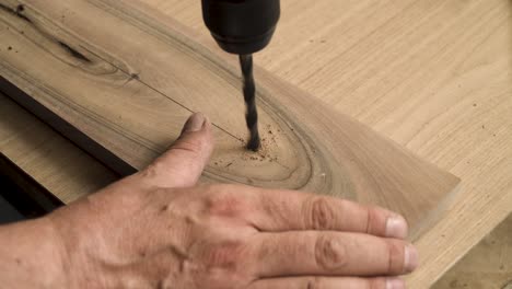 shot of a person drilling in a wooden plank