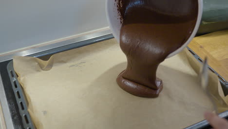 Woman-Pouring-Chocolate-Brownie-Dough-Into-Baking-Tray-From-Bowl---Zooming-to-close-up