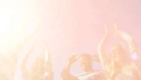 multi-ethnic group of diverse diverse young people jump and throw colorful powder in the air in celebration of holi festival. they have enormous fun on this sunny day.