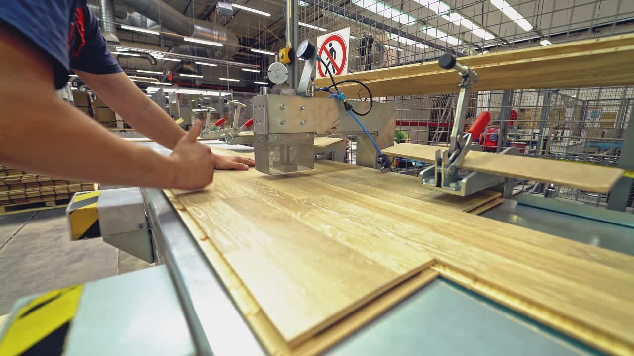Carpenter working with Industrial tool in wood factory. Manufacture of flooring, parquet processing