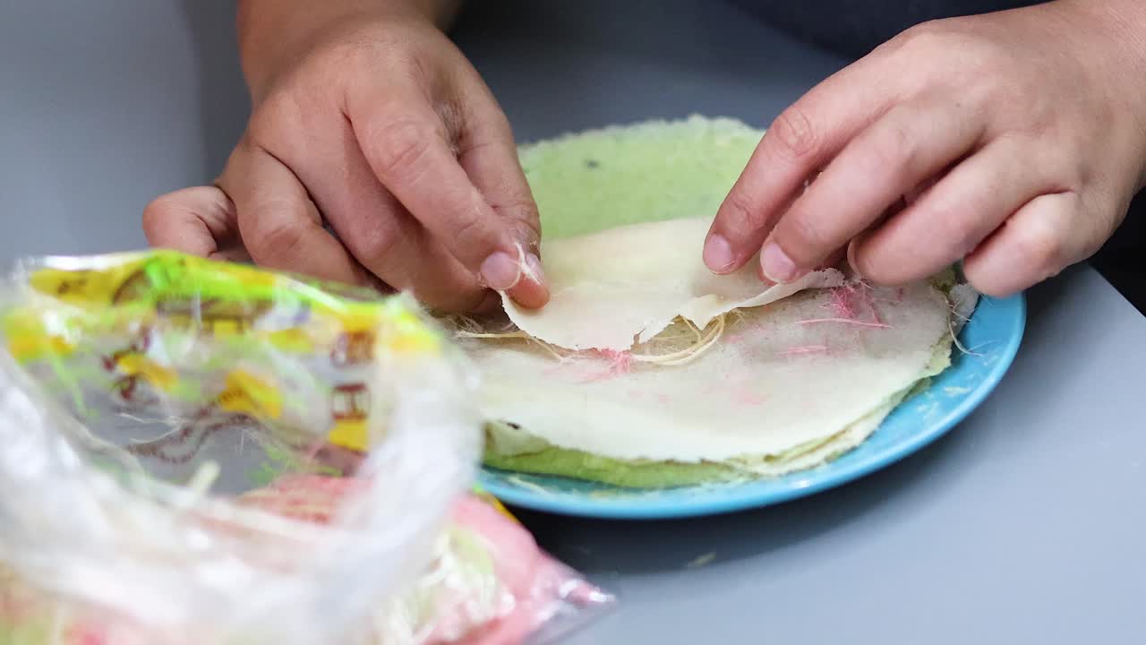 손 은 다채로운 면화 사탕 크레프 를 준비 하고 있다