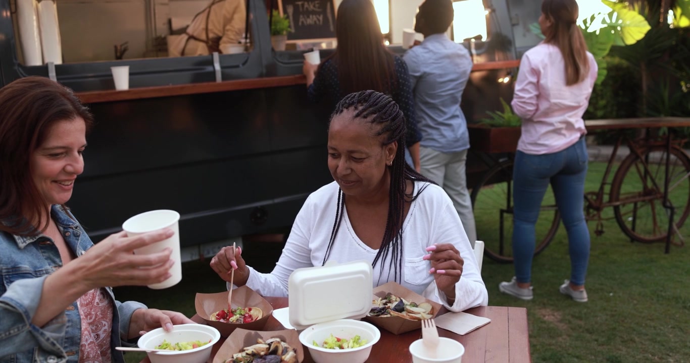 Happy Diverse Women Enjoying Food at an Outdoor Food Truck Event