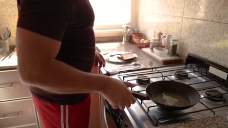 Eine-Detaillierte-Aufnahme-Eines-Mannes-In-Einem-Kastanienbraunen-T-Shirt,-Der-In-Einer-Gemütlichen-Küche-Kocht