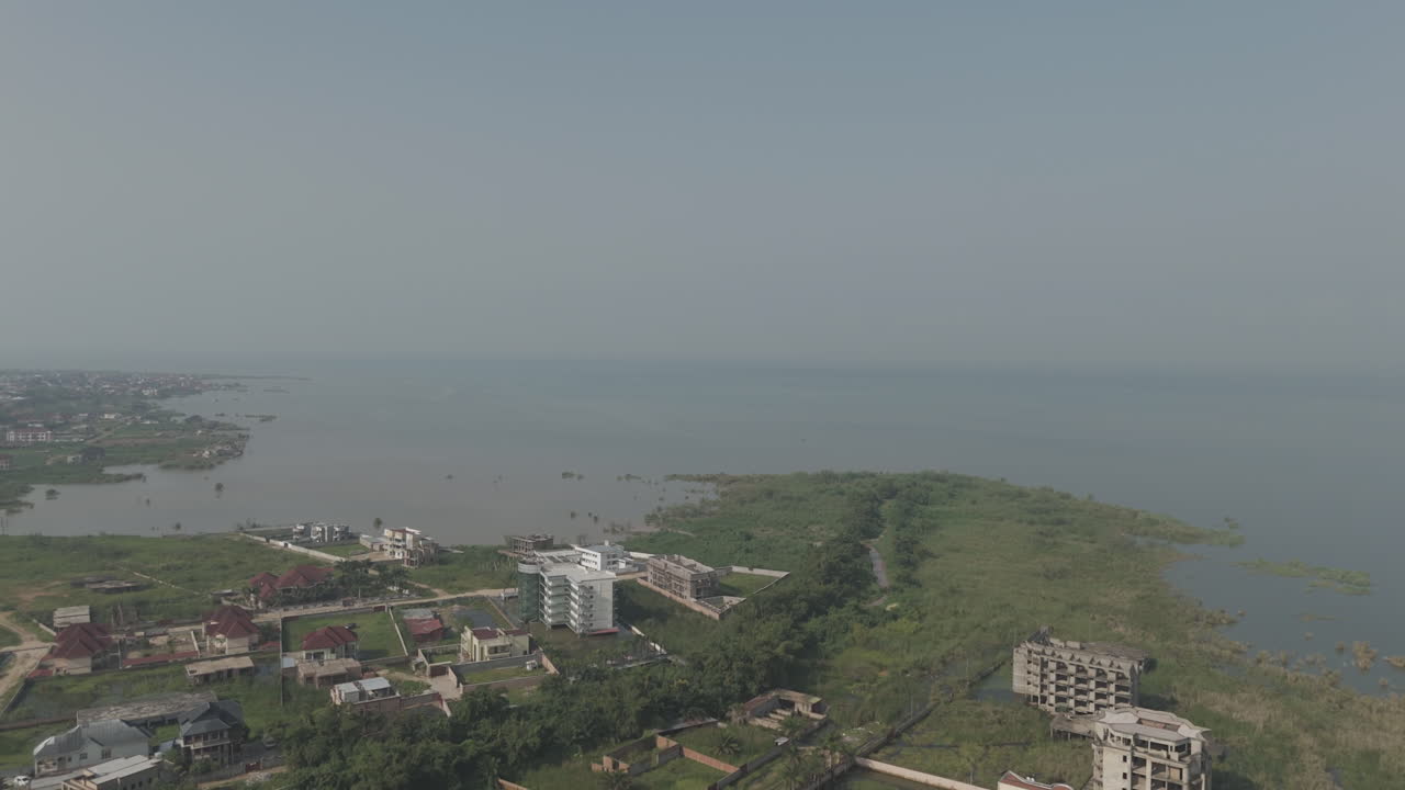 Sideways drone shot above Bujumbura Burundi Africa looking over the houses and lake Tanganyika with mist and pollution in the air LOG