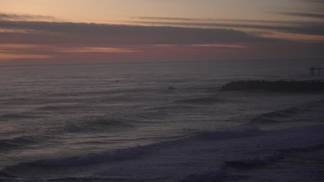 surfers enjoy a serene sunset at the beach