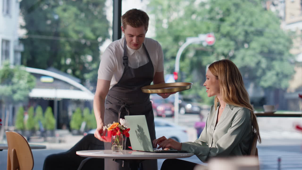 Happy freelancer working cafe typing on laptop. Smiling woman answering email