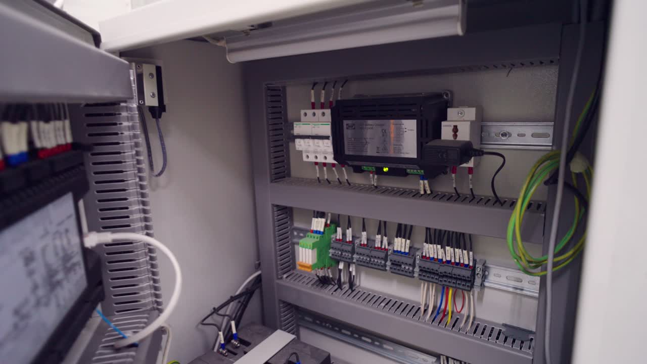 Industrial electrical control panel with wiring terminals breakers and monitoring device inside factory power cabinet