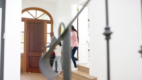 african american parents, son and daughter welcoming visiting grandparents, copy space, slow motion