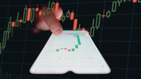 hombre examinando el gráfico de velas en un teléfono inteligente