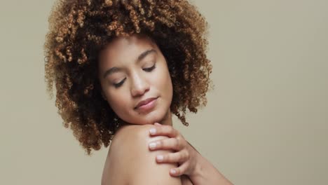 biracial woman with dark curly hair with copy space on beige background, slow motion