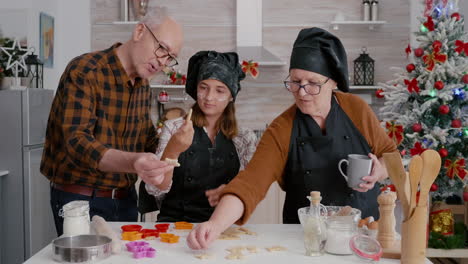 grandparents teaching granddaughter how prepare gingerbread dessert shape