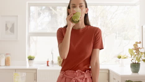 smiling woman in kitchen wearing casual outfit, enjoying bright morning light