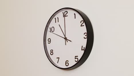 a close-up 4k shot of a classic black and white wall clock filling the frame, showing the time as 11:00 with the second hand at 9 rolling through the hour.