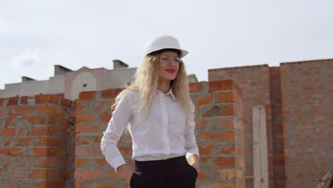a female architect in business attire stands on the top floor in the open air at a construction site. the architect inspects the object