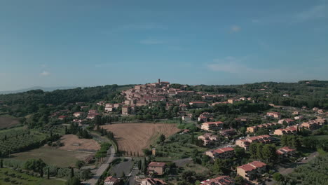 aerial wide view drone descends on tuscan settlement in italian hillside