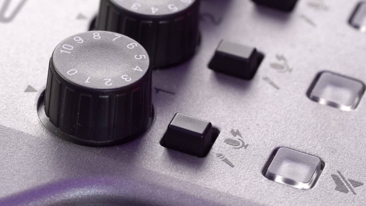 Macro close up view of hand pressing black button on audio mixer with clear detail
