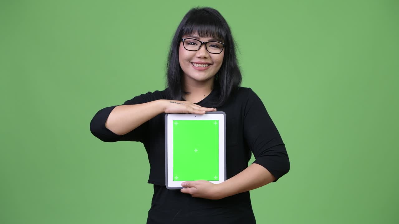 Beautiful Asian businesswoman showing digital tablet and thinking