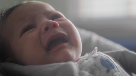 un bebé llorando en una silla alta