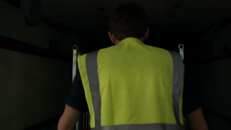 man loads roll cage into back of truck, back view shot on r3d