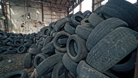 a bunch of car tires are in an abandoned factory. view of old factory inside. close-up.
