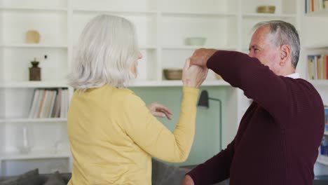 happy senior caucasian couple embracing and slow dancing togther