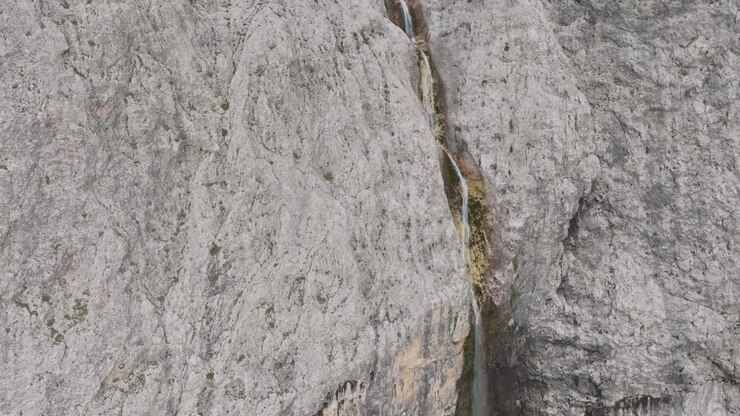 Cinematic aerial tilt-down view of Murfreit waterfaall near Passo Gardena