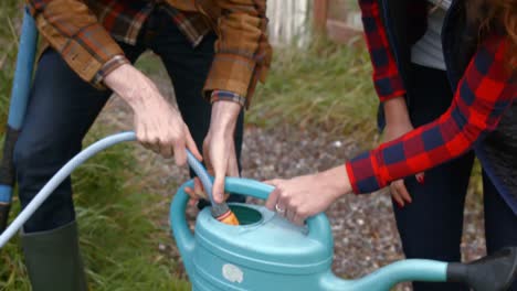 couple putting water in the watering can