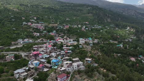 una toma aérea de un dron que muestra las montañas kinner kailash cubiertas de nieve detrás de kalpa en himachal pradesh.