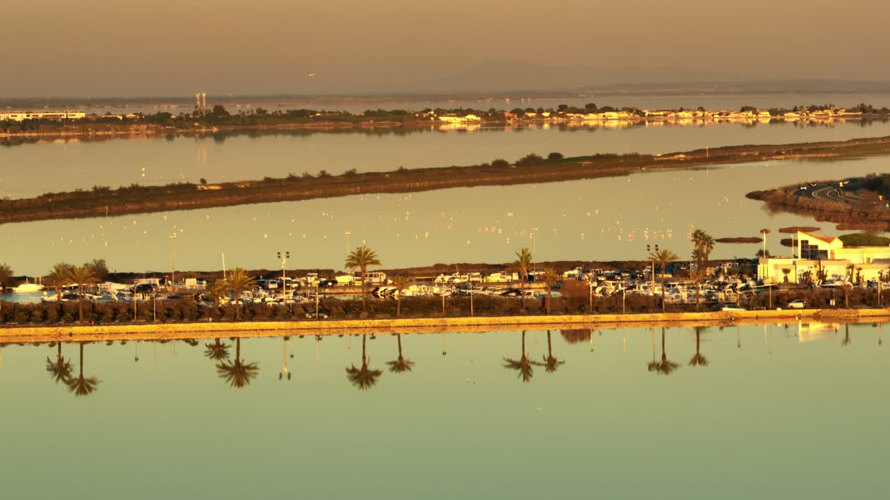 아름다운 종려나무가 도로를 따라 반사됩니다. 비행기의 배경은 공중에서 해가 지는 모습입니다.