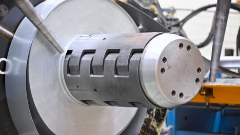 bobinas industriales de chapa metálica conectadas con la máquina de formación de perfiles de chapa metalica.