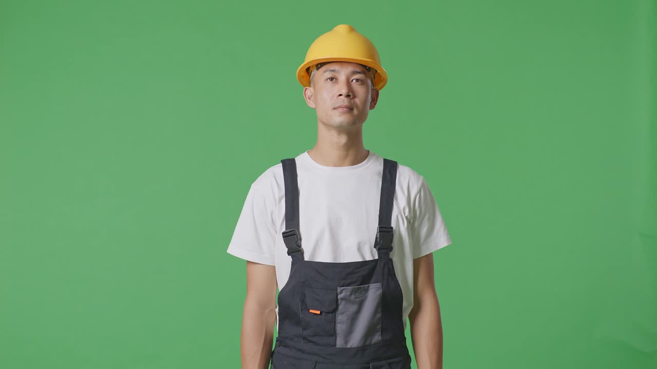 Asian Man Painter Wearing Safety Helmet Standing And Look Around In The Green Screen Background Studio