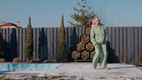 stylish woman dancing in winter park by a pool